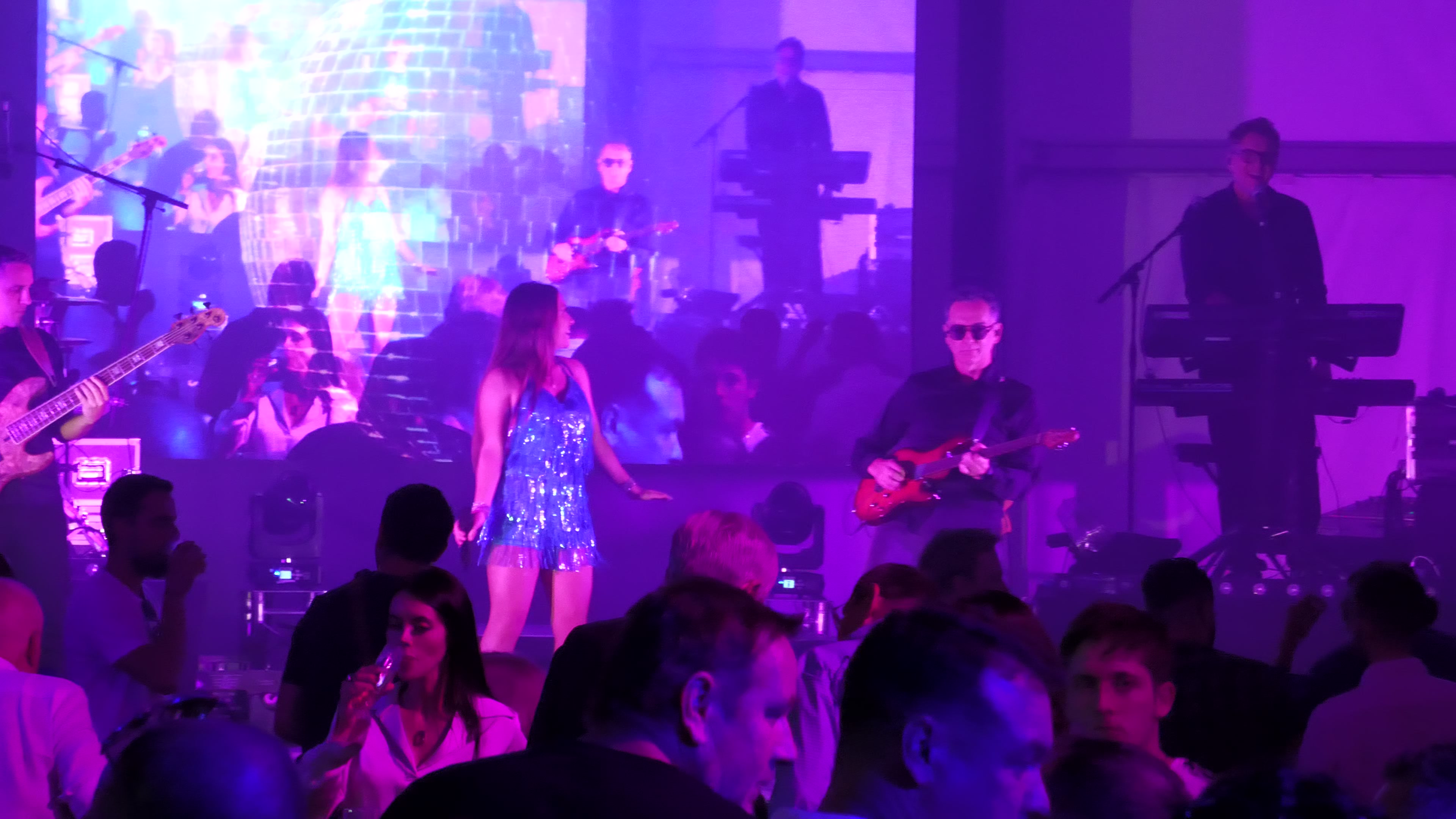 Concert live — chanteuse, musiciens, écran LED, public dansant