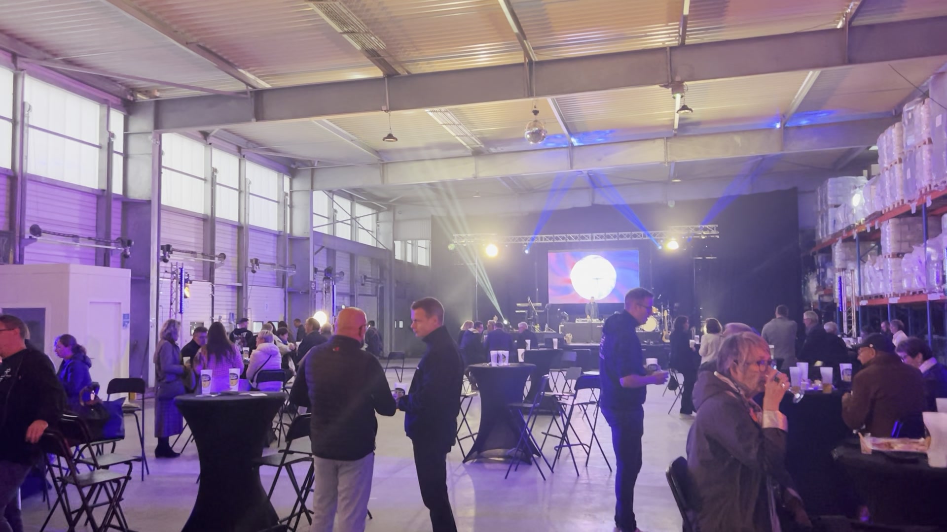 Soirée entreprise — scène, écran, tables cocktail, éclairage ambiance
